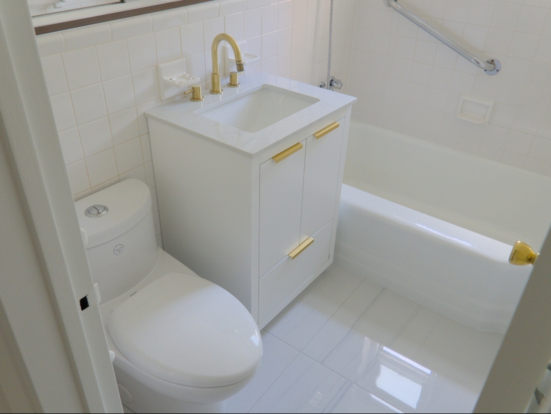 Modern White Bathroom Renovation with Gold Accents